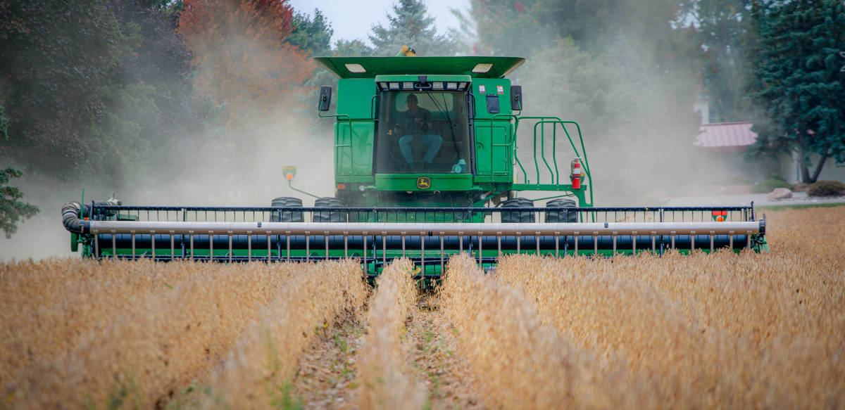 A worker drives a tractor through a field.