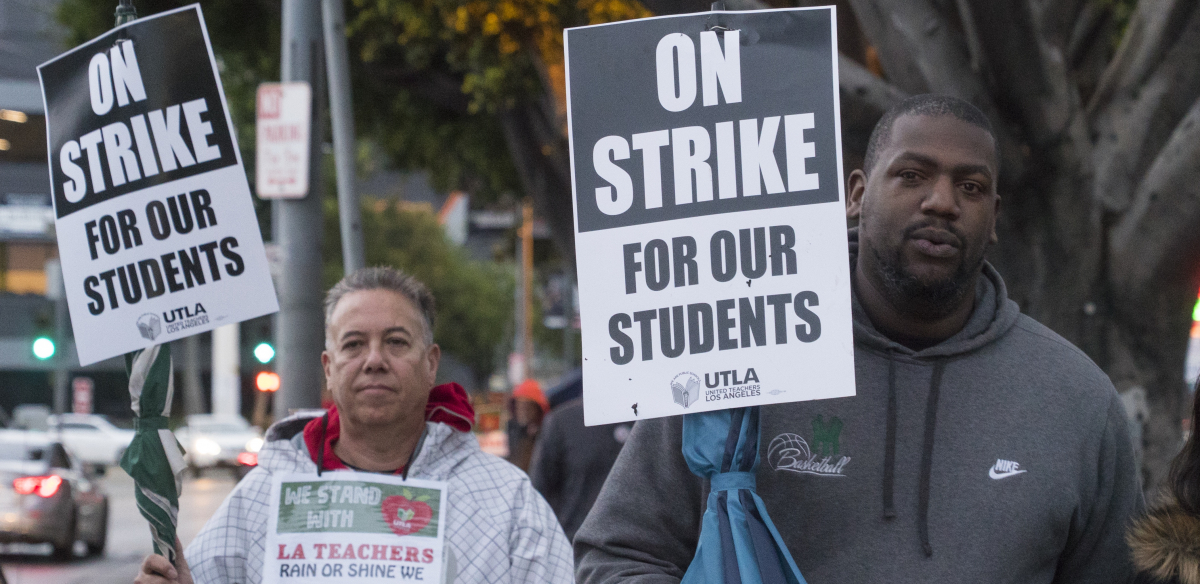 A white man and a Black man hold signs: "On Strike for Our Students; UTLA"