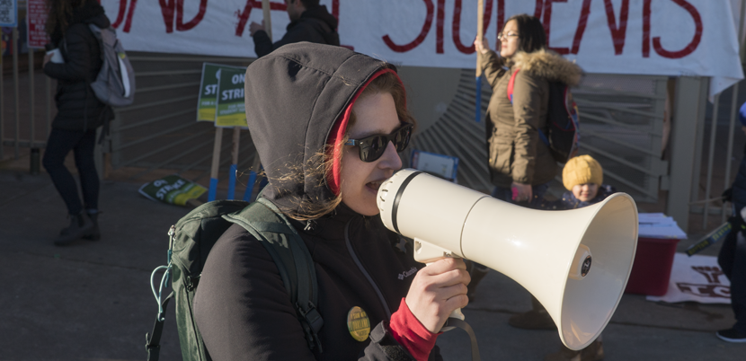 Woman on megaphone supporting Oakland teachers and students during Oakland teacher strike.
