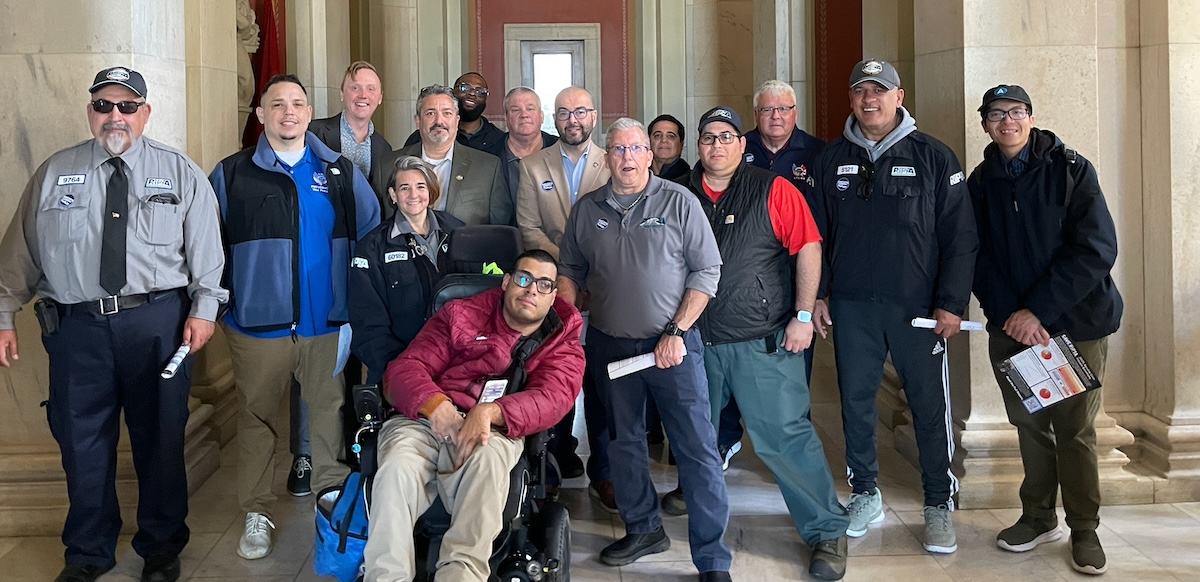 A group of 10 people poses for the camera.  One is in a wheelchair.