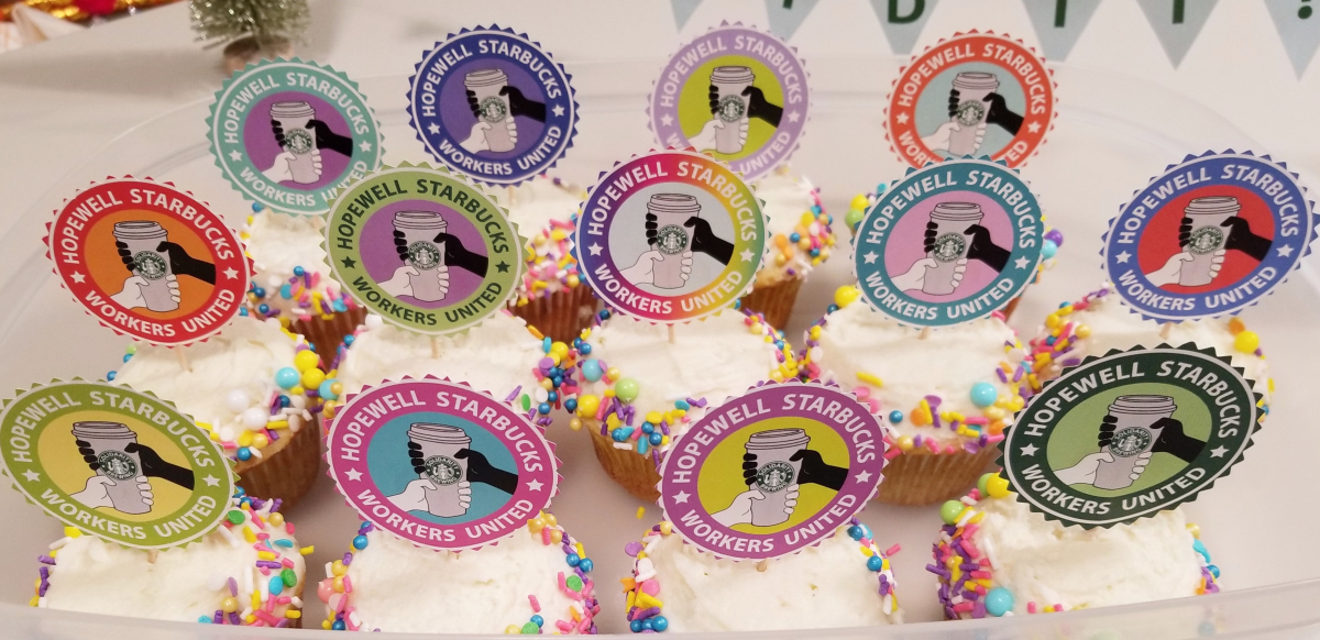 A dozen cupcakes with rainbow colored sprinkles and cupcake toppers that read Hopewell Starbucks Workers United