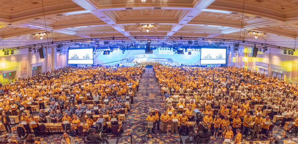 Shot from above and in front of huge crowd of people in a ballroom, wearing matching UFCW yellow shirts.