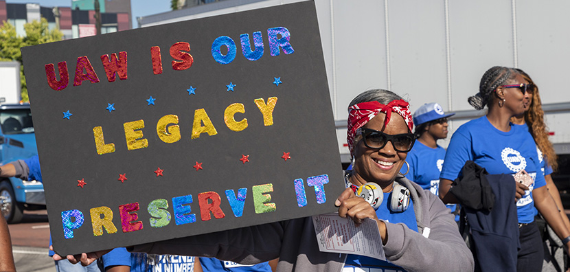 Woman auto worker holding up sign