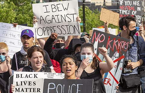 Marchers with signs including "IBEW Against Oppression" and "No KKKops"