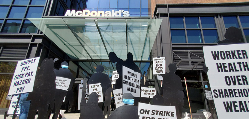 black silhouette cutouts representing workers on trike in front of mcdonald's
