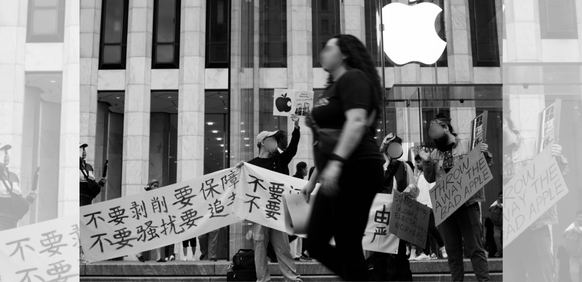 People march in front of an Apple store in New York City, holding signs and banners in English and Chinese. Their faces are blurred out in the photo due to fears of retaliation from the Chinese government against them and their families.