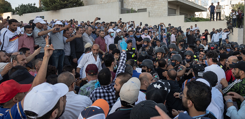 Crowd of teachers and supporters protesting in Amman in front of building, some with raised arms, on July 29 2020