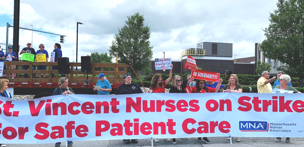 People outside hold a huge banner: "St. Vincent Nurses on Strike for Safe Patient Care; MNA"