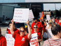 Red-shirted hospital workers march with signs.