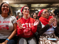 Five women sit applauding, one is wearing a CTU T-shirt, another says “we care” with a drawing of a chalkboard