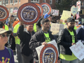 Members of the Laborers Union march in a No Kings demonstration, holding signs that say Immigrant Rights Are Workers Rights and An Injury to One Is an Injury to All.