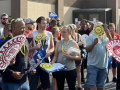 A crowd with UAW signs gathers outside a union hall for a rally.