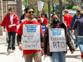 Workers in red shirts march outside the Washington Post's office, carrying signs with slogans including "Flexible RTO" (which stands for return to office) and Washington Post Tech Guild Unite!
