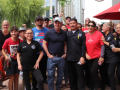 A group 25 of workers in red shirts gather near an umbrella saying Panda Express