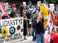A rally with 30 or so people with a mixture of colorful signs, including Painters Union and a “We Want Good Jobs and Health Environments” banner