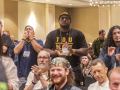 TDU convention attendees are shown sitting and standing, clapping for a speaker, in the hotel ballroom, under a chandelier.