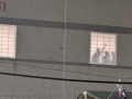 A photo taken at night shows detainees silhouetted in the prison window, one with fist raised. 